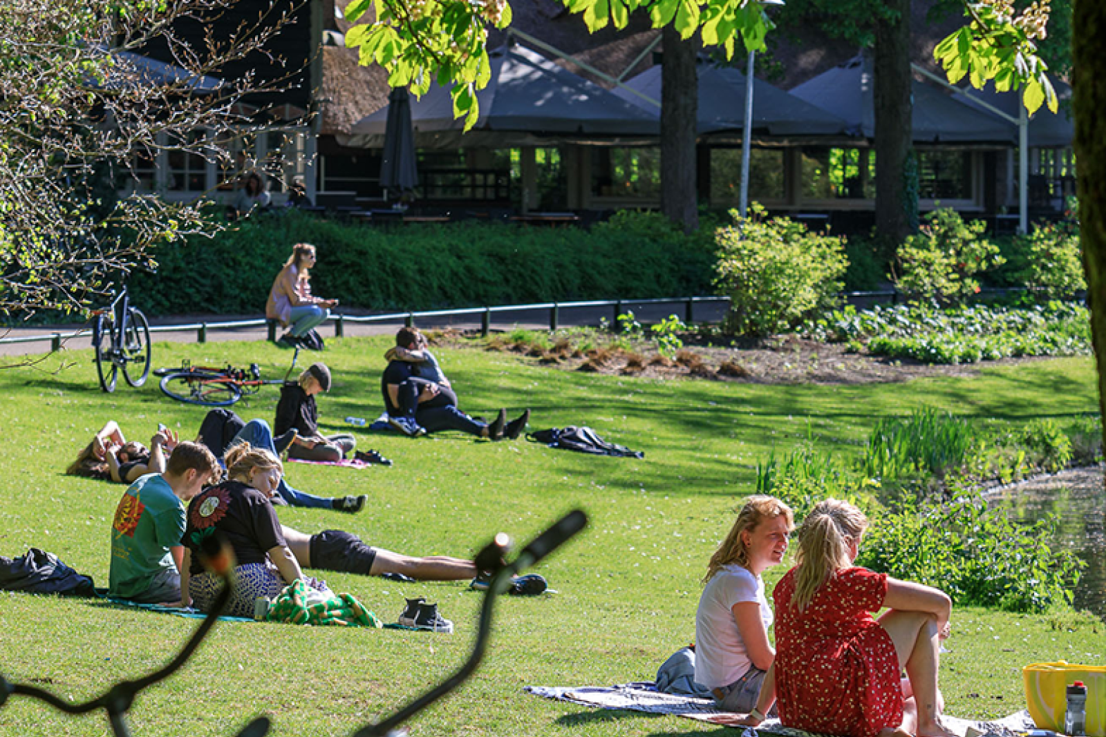 Mensen in het Wilhelminapark in Utrecht genieten van het mooie weer