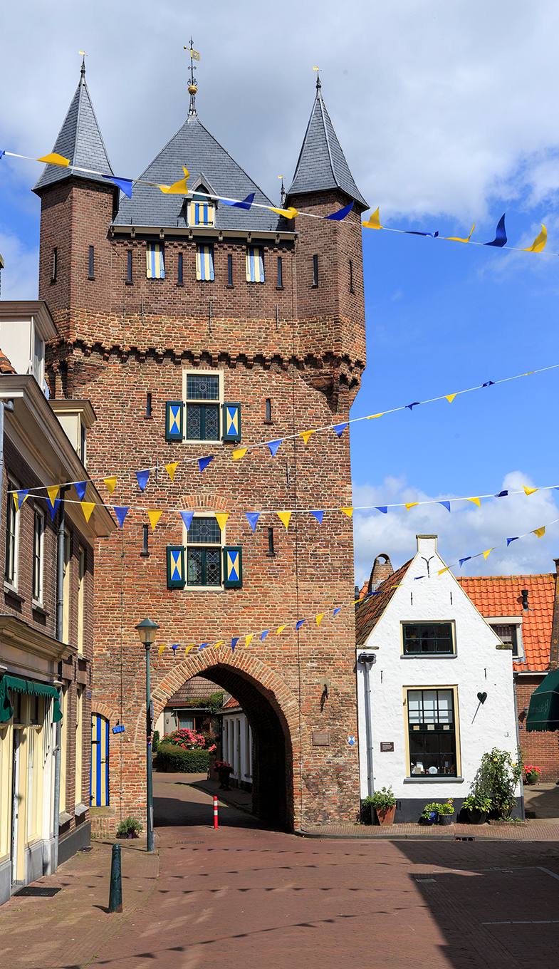 Dijkpoort in Hattem, straatje versierd met blauwe en gele vlaggetjes.